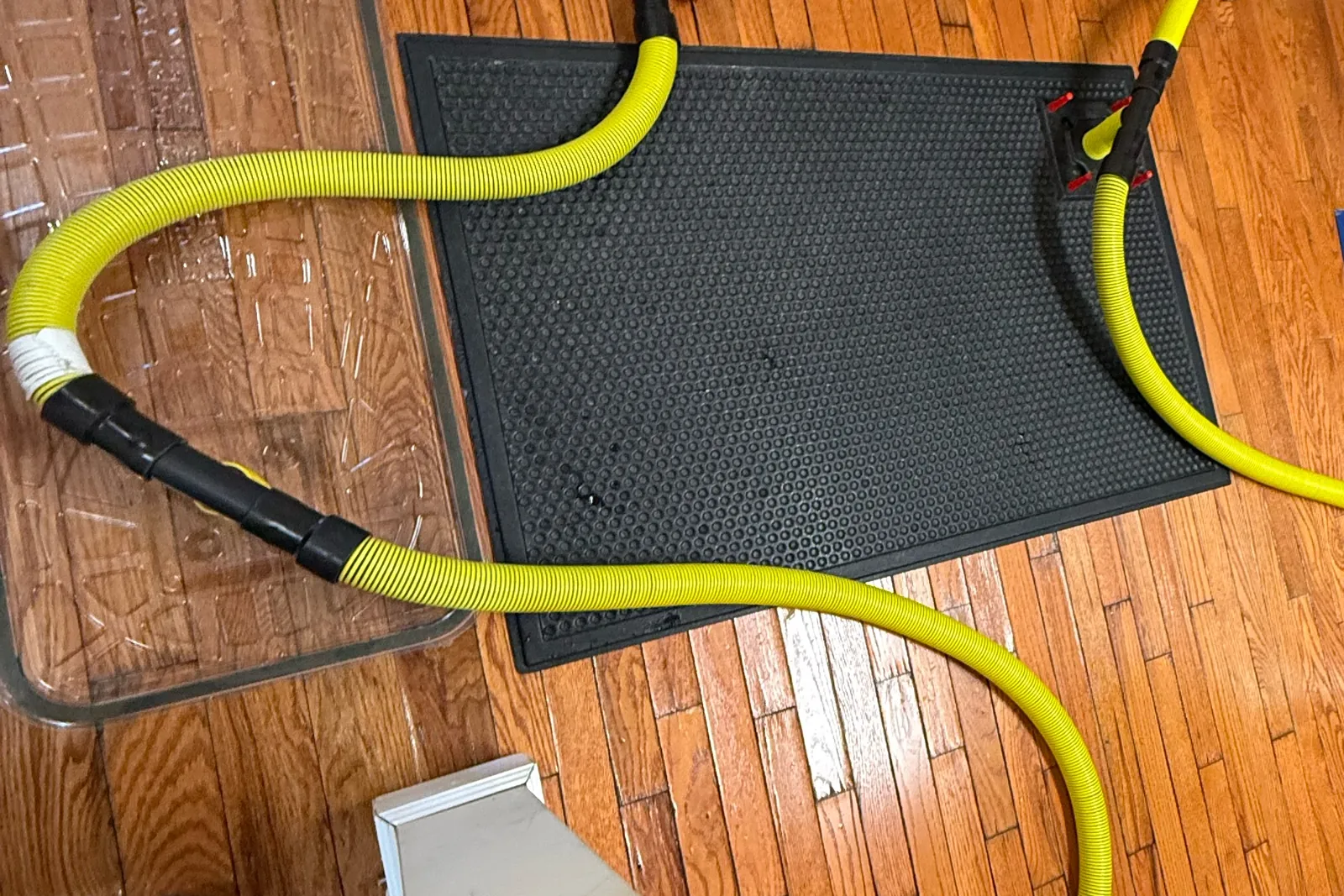 Drying mats and hoses pulling water out of a hardwood floor